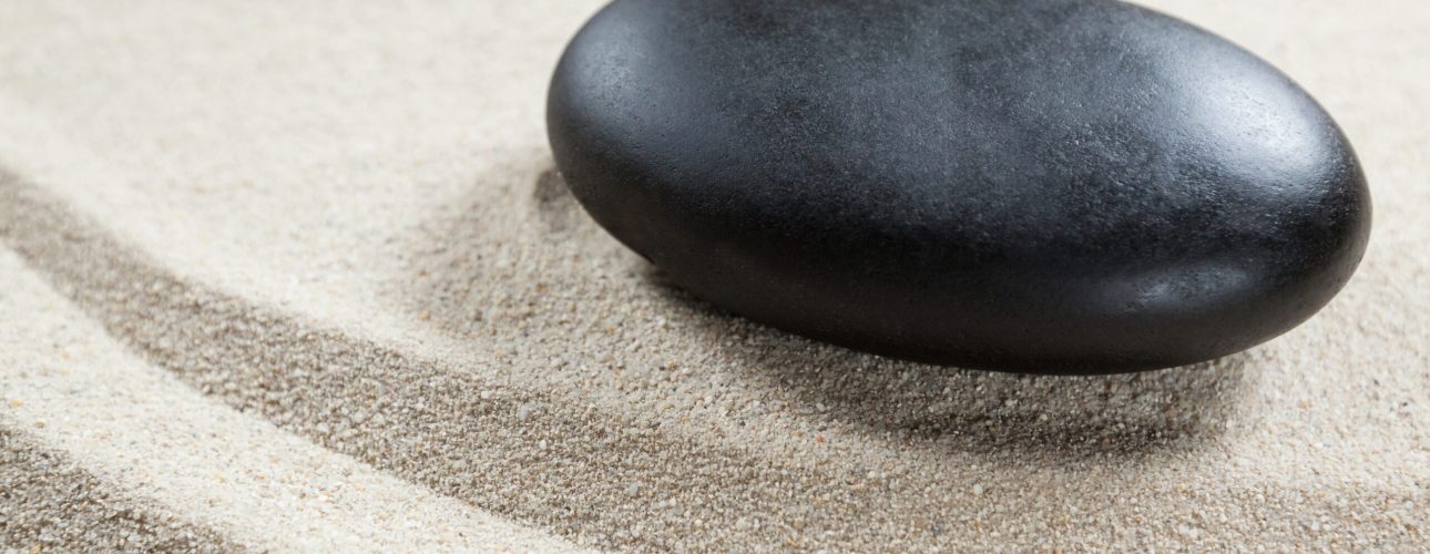 Black pebble stone on a sand